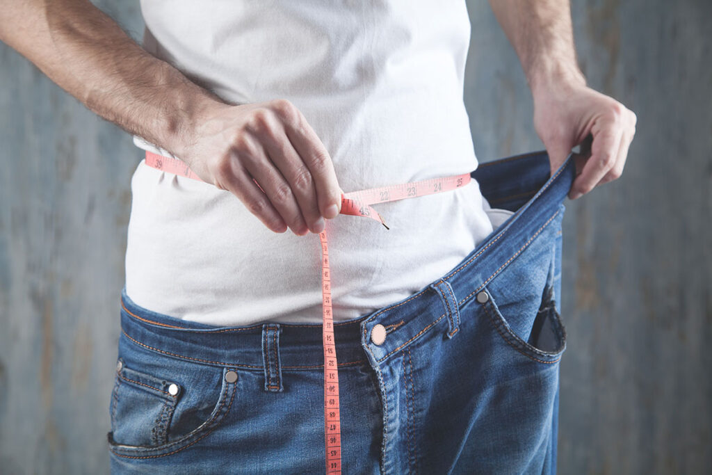 man measuring waist